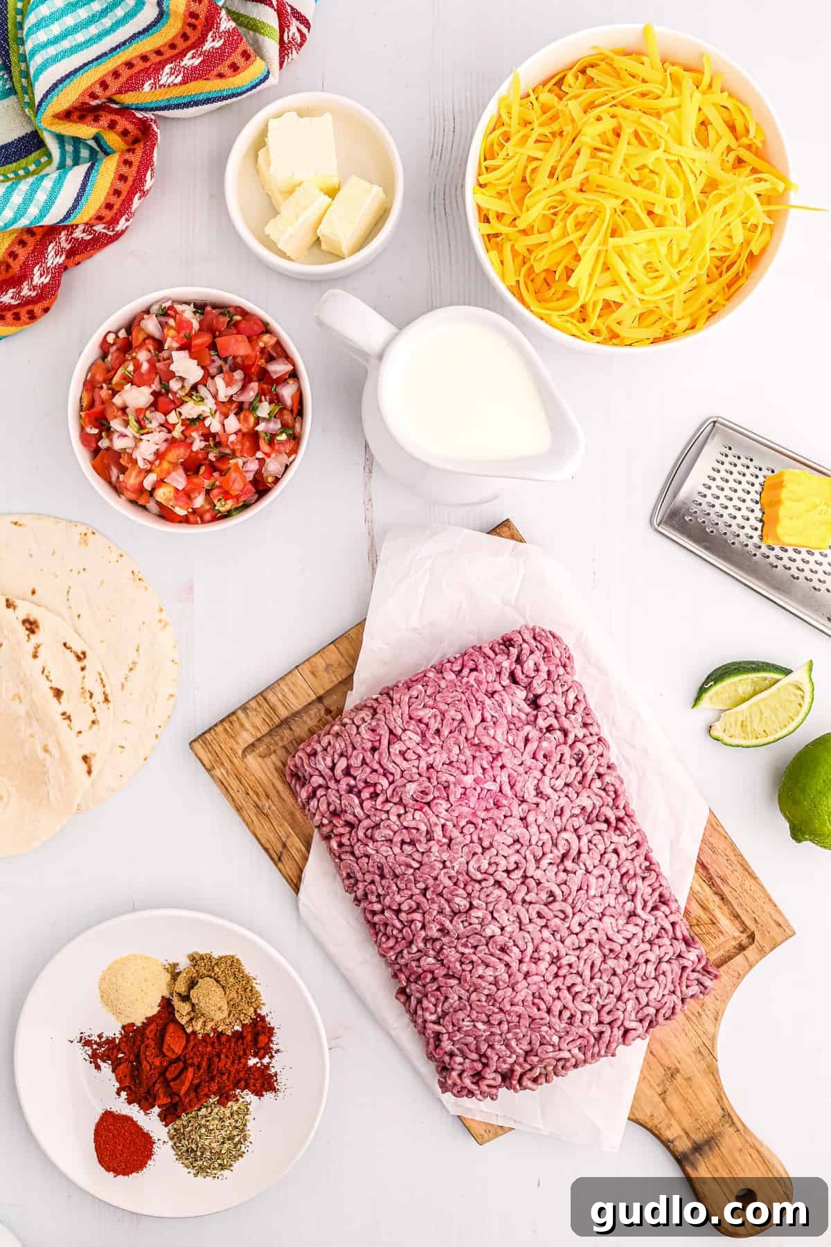 Tex-Mex Lasagna 3 All the fresh ingredients laid out on a counter, including ground beef, tortillas, spices, pico de gallo, heavy cream, and cheddar cheese, ready for making taco lasagna.