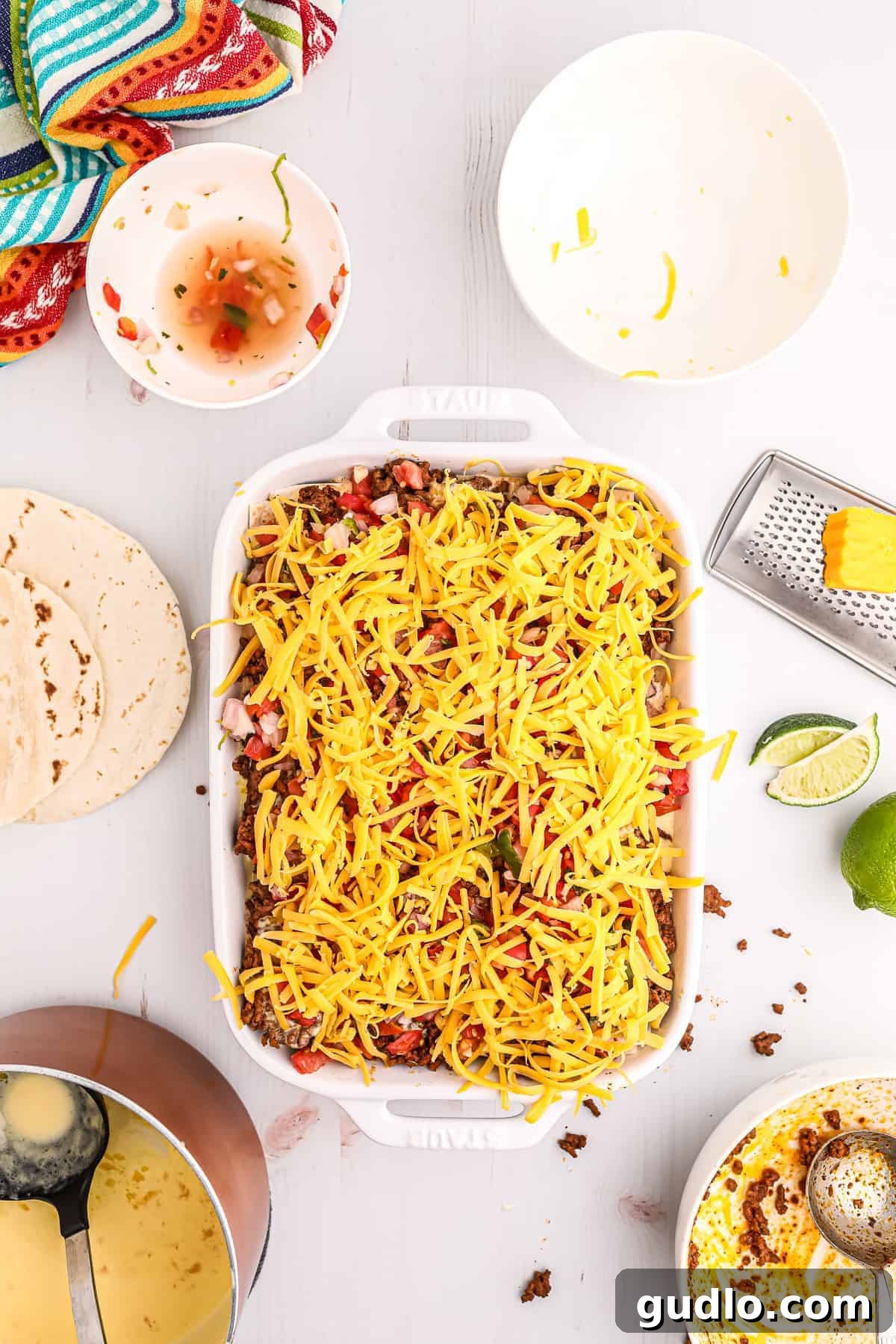 Tex-Mex Lasagna 9 Shredded cheddar cheese sprinkled generously on top of the unbaked taco lasagna, ready for the oven.