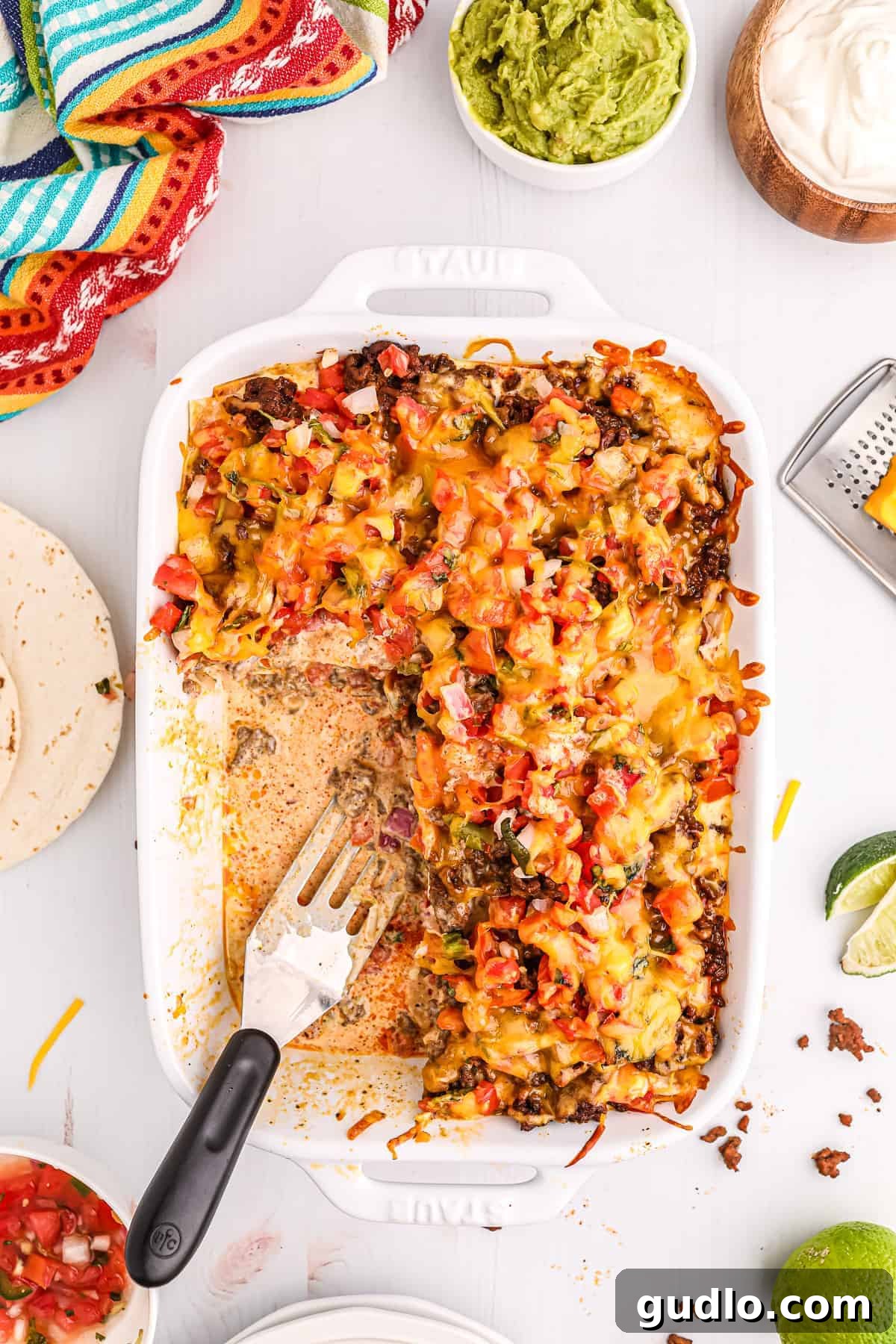 Tex-Mex Lasagna 10 Close-up of a serving of Taco Lasagna with vibrant toppings like guacamole and sour cream.