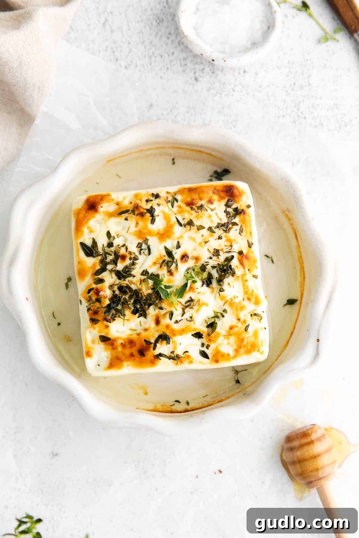 Flame-Kissed Feta 2 Perfectly grilled feta drizzled with honey and sprinkled with herbs on a rustic plate, ready to be served.