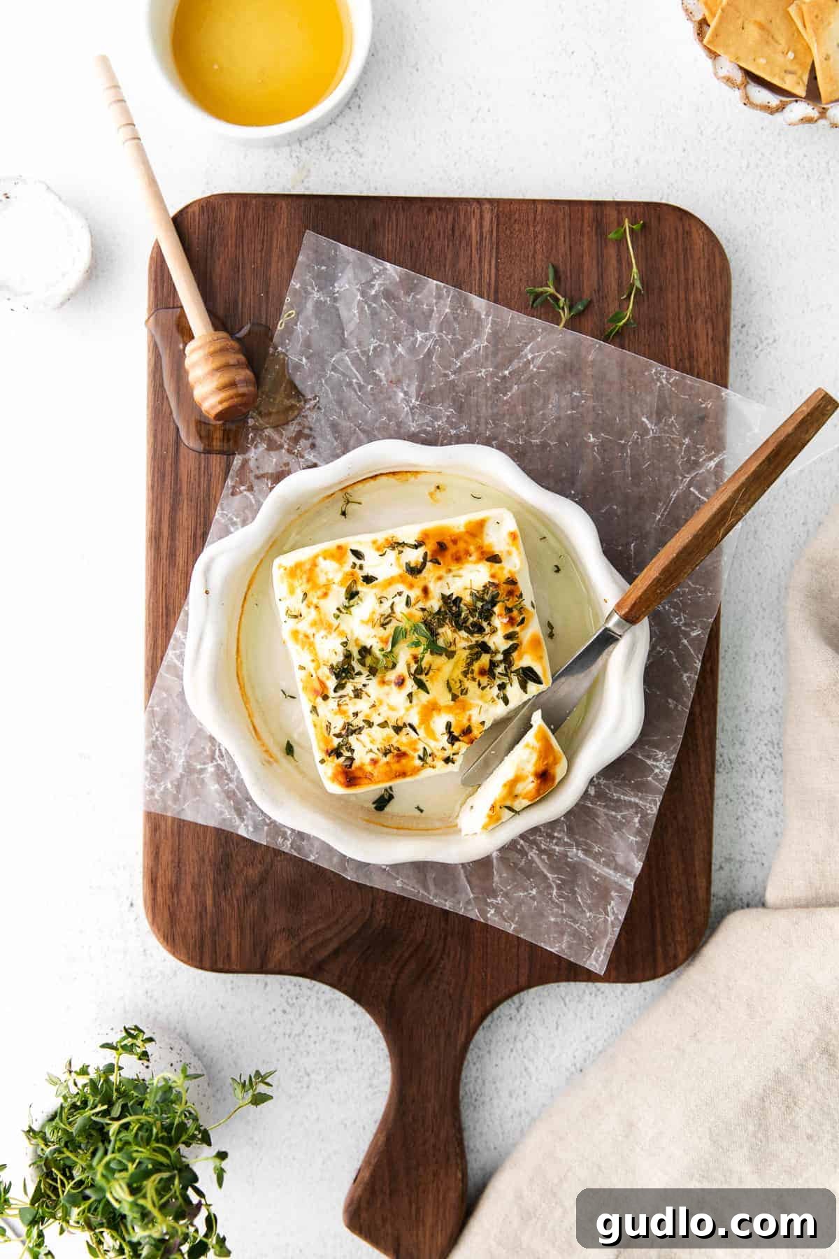 Flame-Kissed Feta 5 A vibrant charcuterie board featuring grilled feta alongside crackers, fresh herbs, and other delicious accompaniments, suggesting it as a perfect addition to any platter.