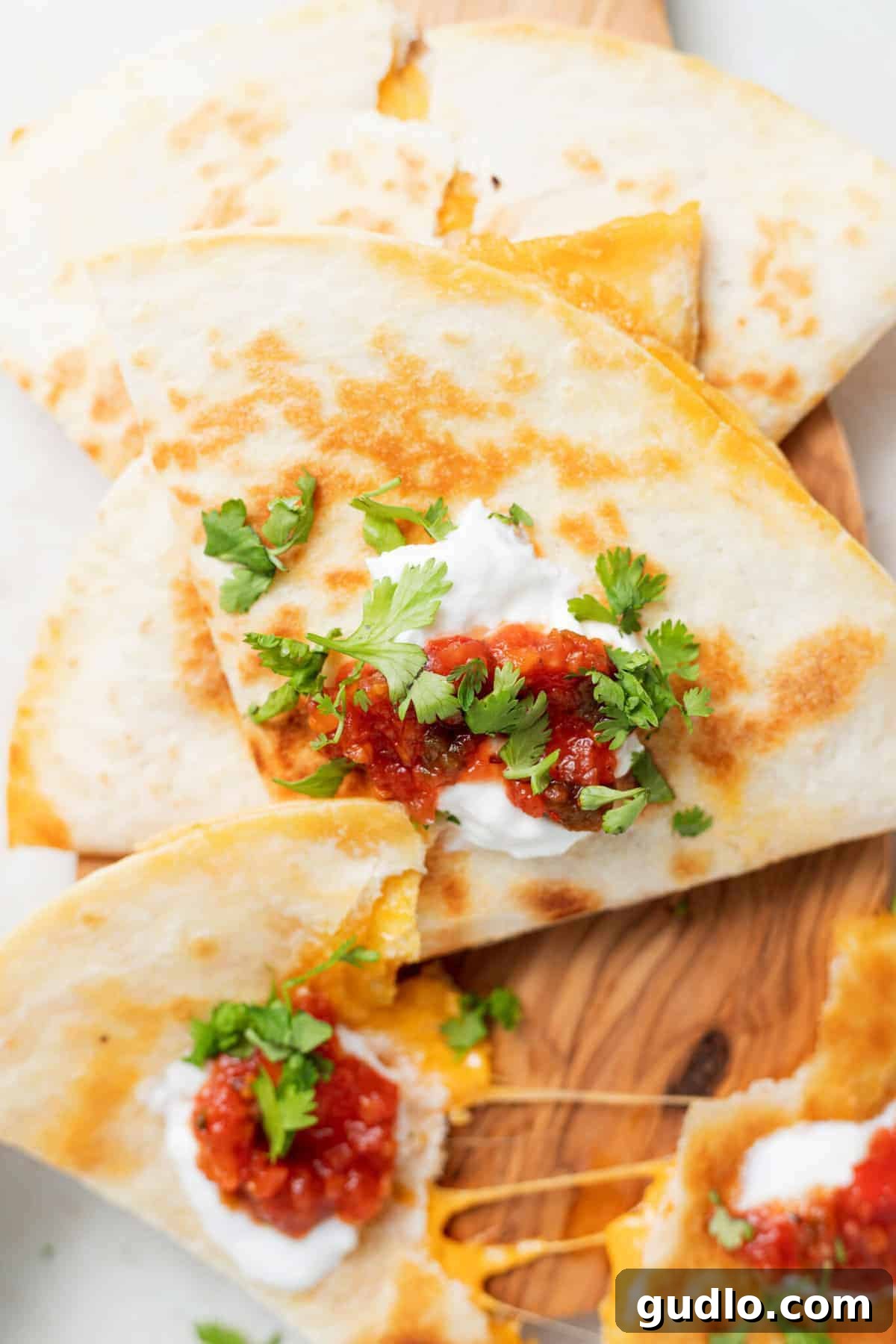 Sliced Cheese Quesadilla with Toppings A beautifully sliced cheese quesadilla, garnished with fresh toppings like salsa and cilantro, showcasing its gooey interior.