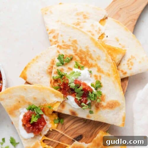 A beautifully golden-brown cheese quesadilla, sliced and served on a wooden cutting board.