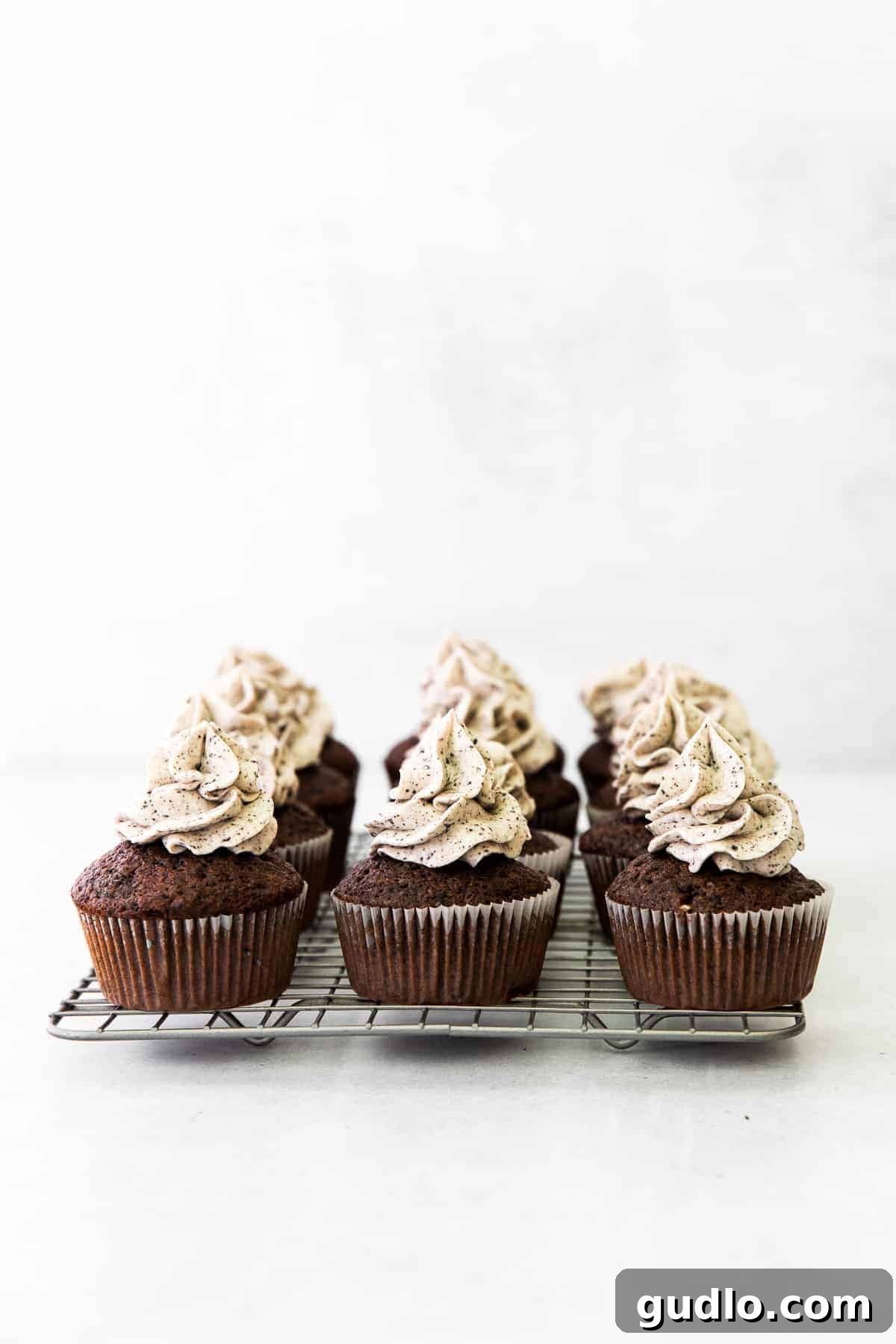 Freshly baked cupcakes cooling on a wire rack, waiting for their delicious frosting.