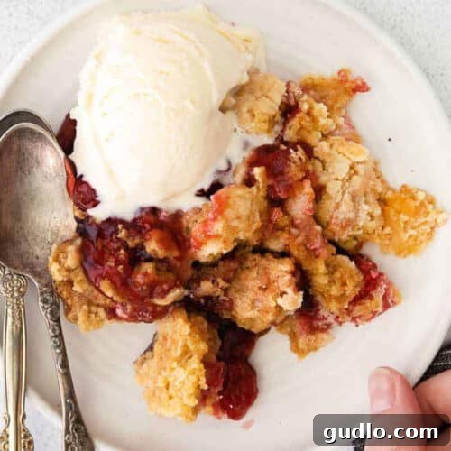 Cherry Cream Cheese Cloud Cake 4 A scoop of ice cream on a white plate next to a slice of dump cake.