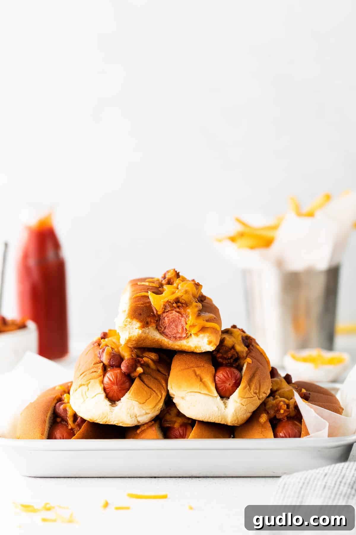 A stack of two chili cheese dogs, generously topped with chili and cheese, promising a hearty meal.