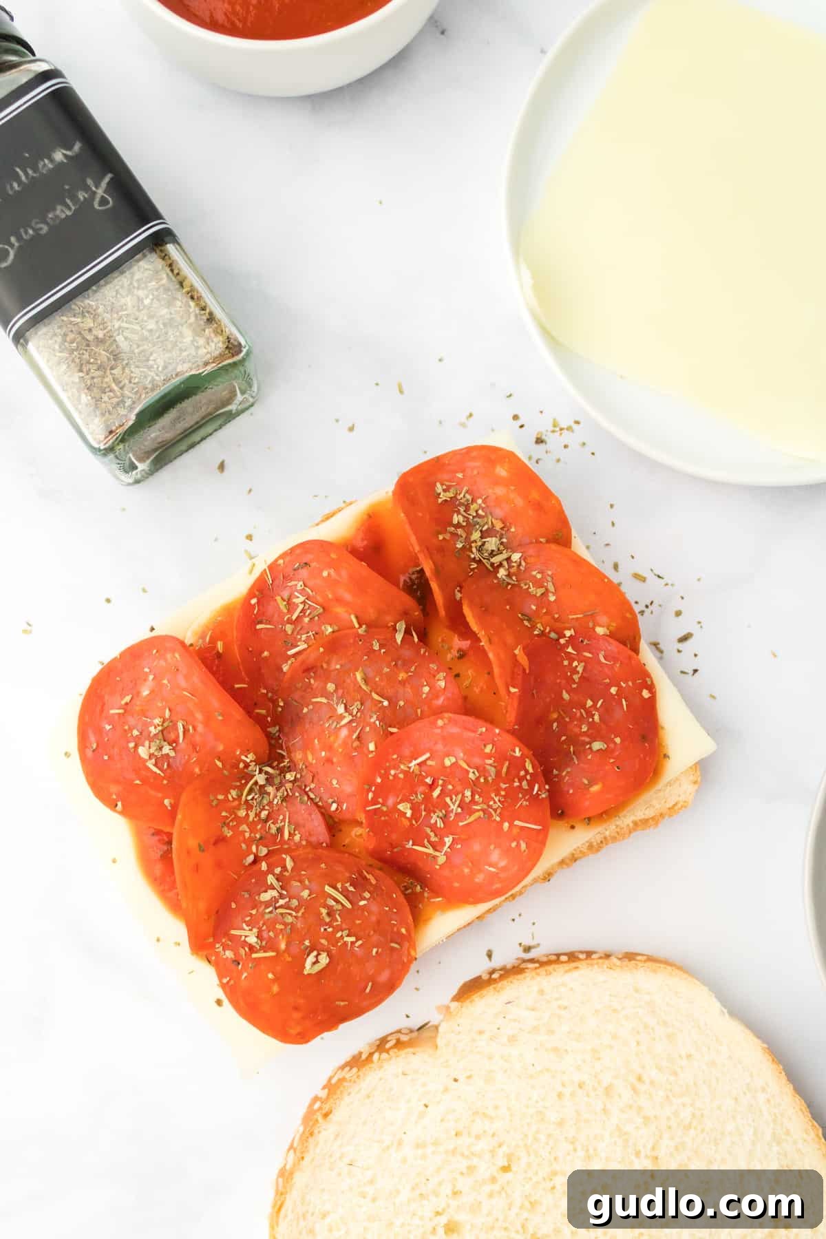 Pepperoni on top of bread, ready for assembly. Pepperoni slices neatly arranged on a slice of bread, ready for the next layer.