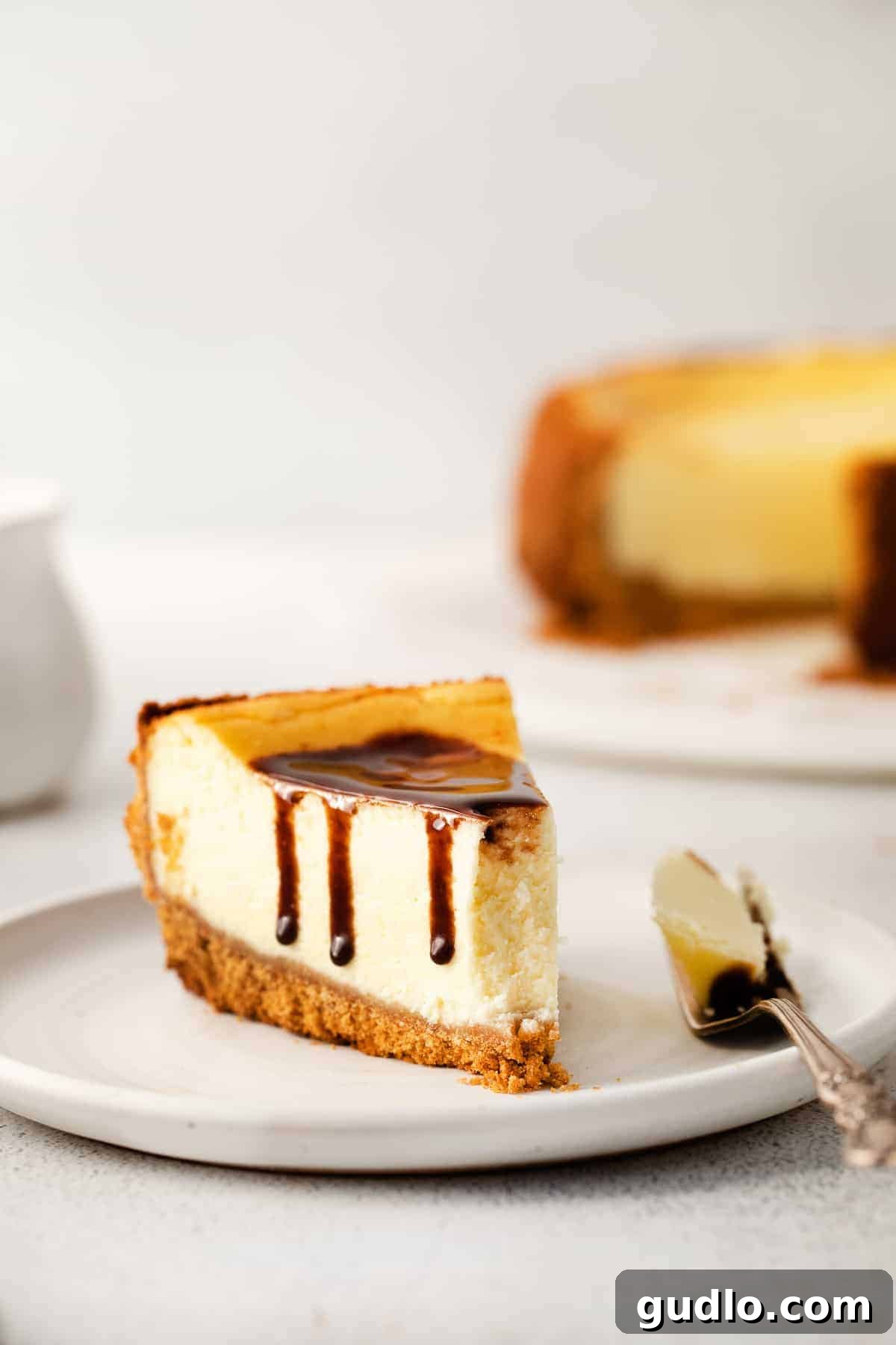 A fork holding a perfect bite of creamy cheesecake, showcasing its smooth texture.