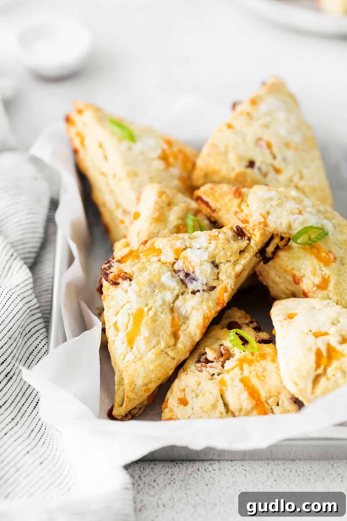 A rustic basket overflowing with freshly baked, golden-brown bacon and cheddar scones, ready to be served.