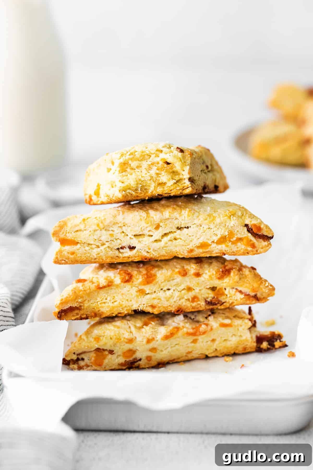 A close-up shot of a freshly baked bacon and cheddar scone, showcasing its perfectly golden exterior and inviting crumb.