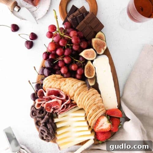 A beautifully assembled chocolate and cheese board with a variety of ingredients.