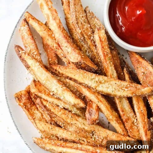 Perfectly cooked air fryer garlic parmesan fries on a plate, ready to be served.