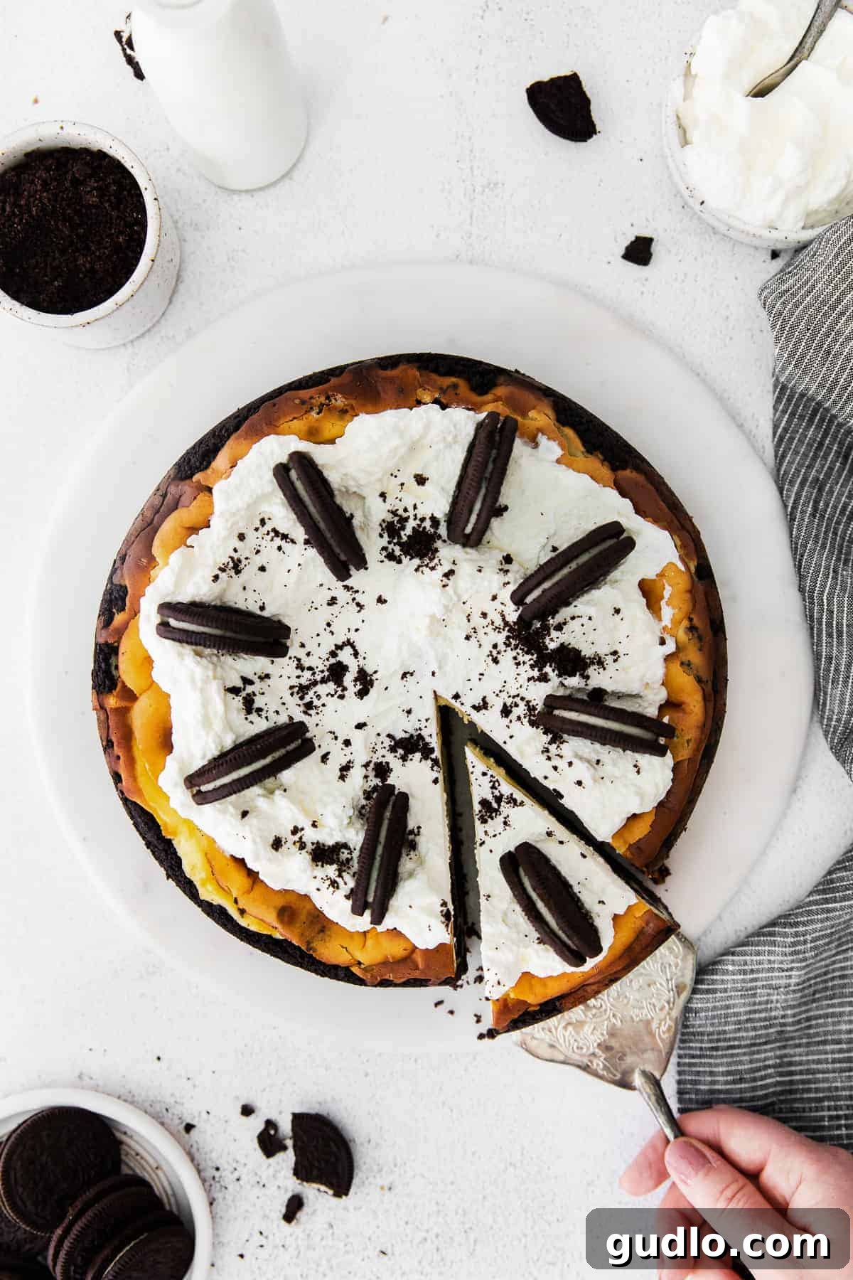 Decadent Oreo cheesecake topped with swirls of whipped cream and whole Oreo cookies, ready for serving.