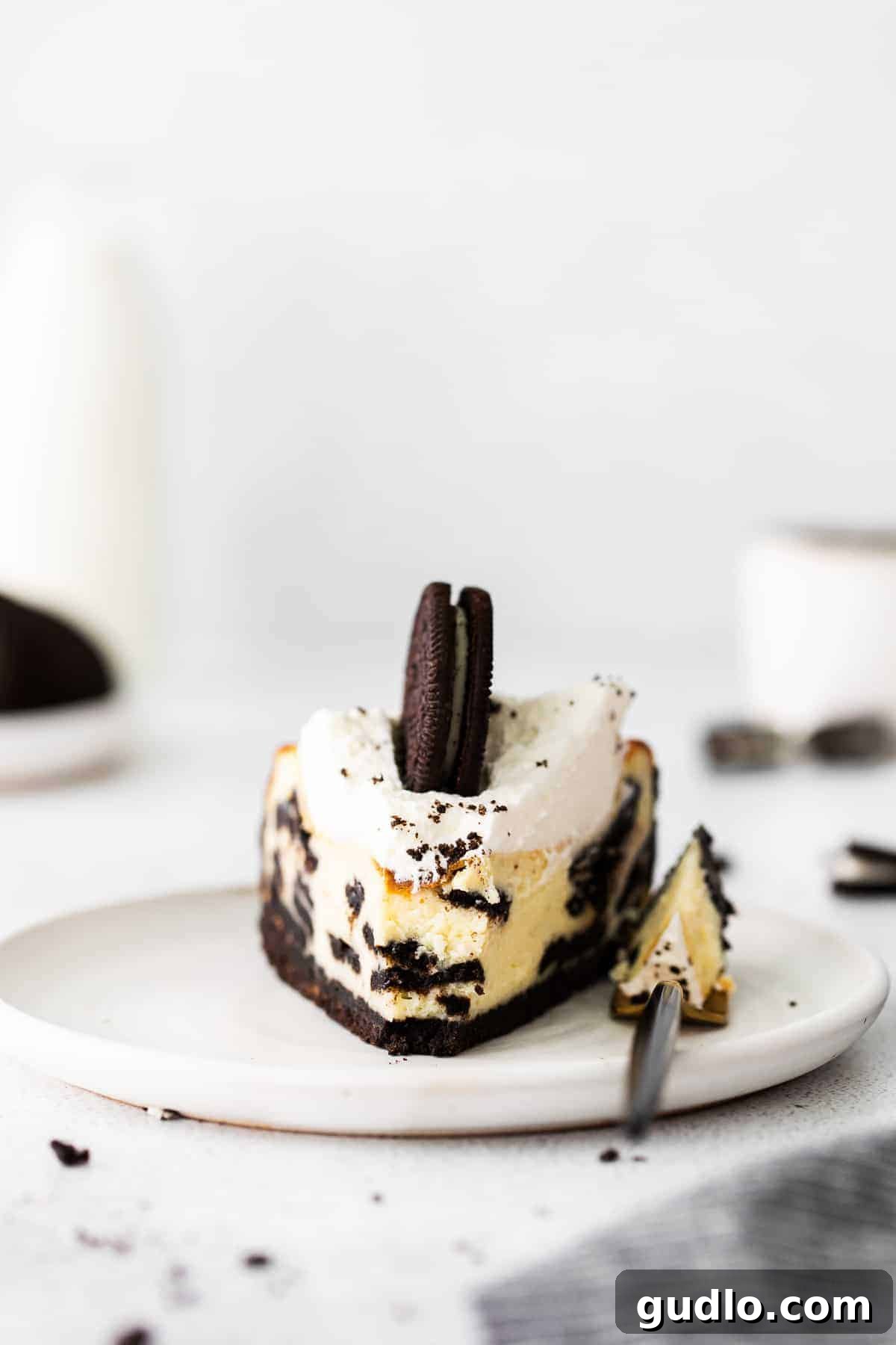 A perfectly portioned slice of Oreo cheesecake on a plate, highlighting its rich layers and inviting texture.