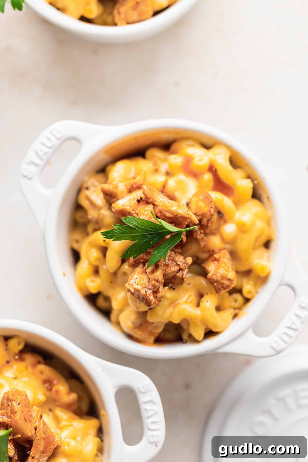 A large bowl of creamy Buffalo Chicken Mac and Cheese, richly topped with diced buffalo chicken and a garnish of fresh herbs, ready to be served.