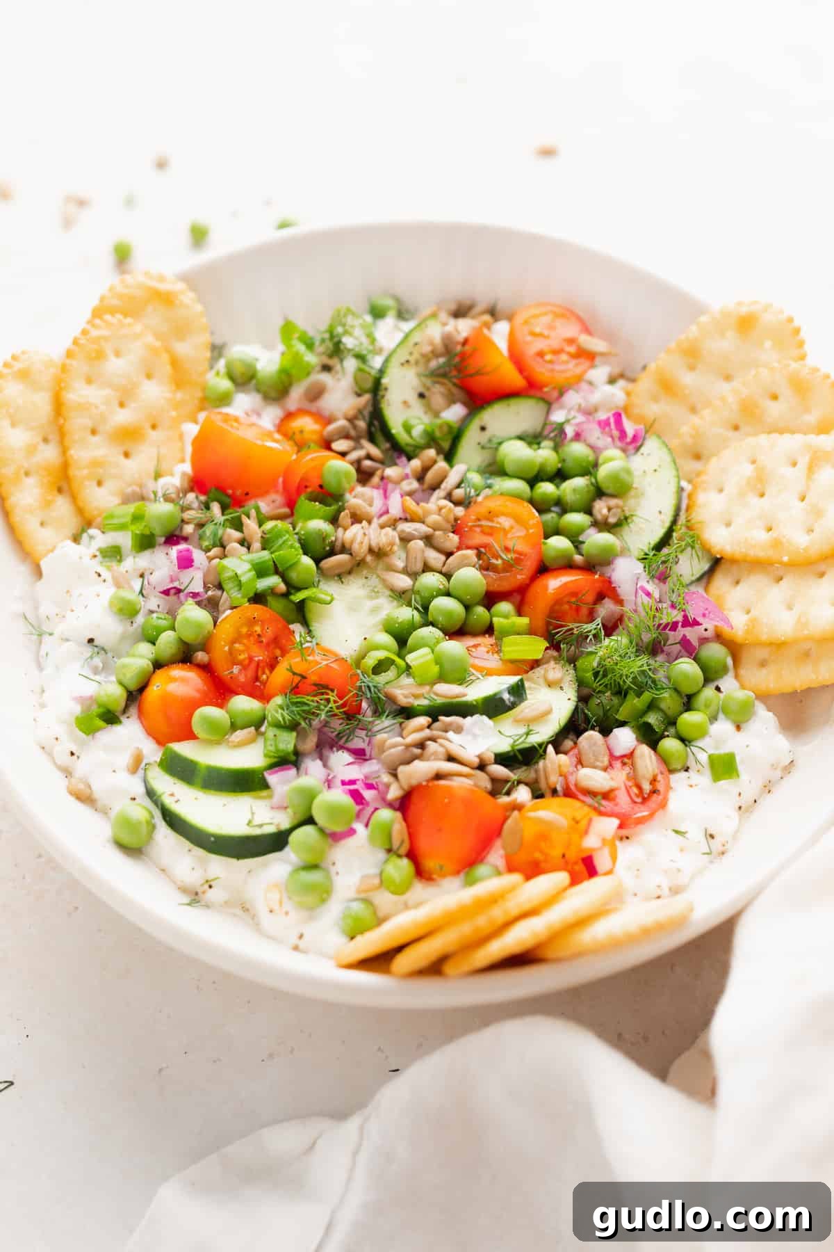 Cottage Cheese Salad with Dipping Crackers A vibrant cottage cheese salad surrounded by an assortment of crackers, beautifully arranged on a rustic wooden board, ready for serving and dipping.