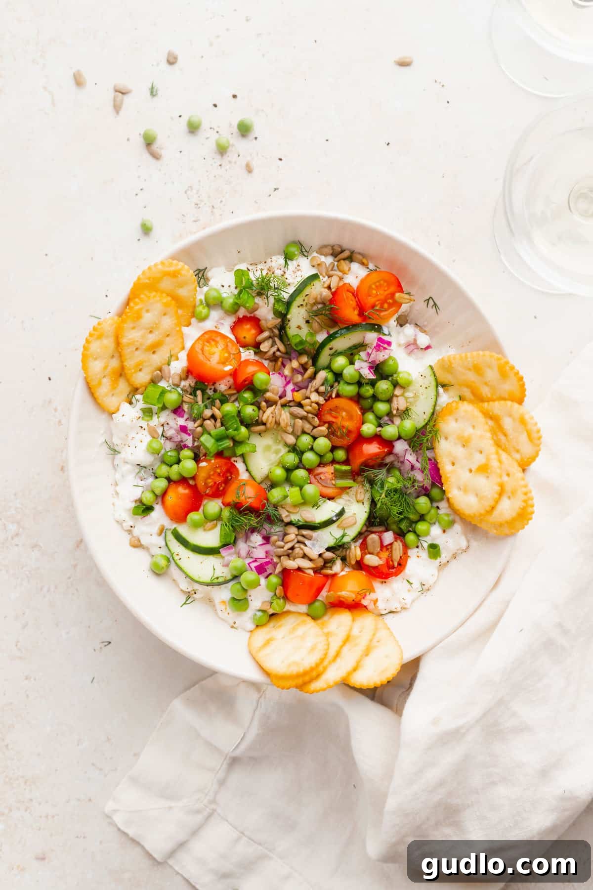 Ready-to-Serve Cottage Cheese Salad with Crackers A bowl of fresh cottage cheese salad with all its vibrant toppings, ready to be served, accompanied by various crackers for dipping, creating an inviting spread.