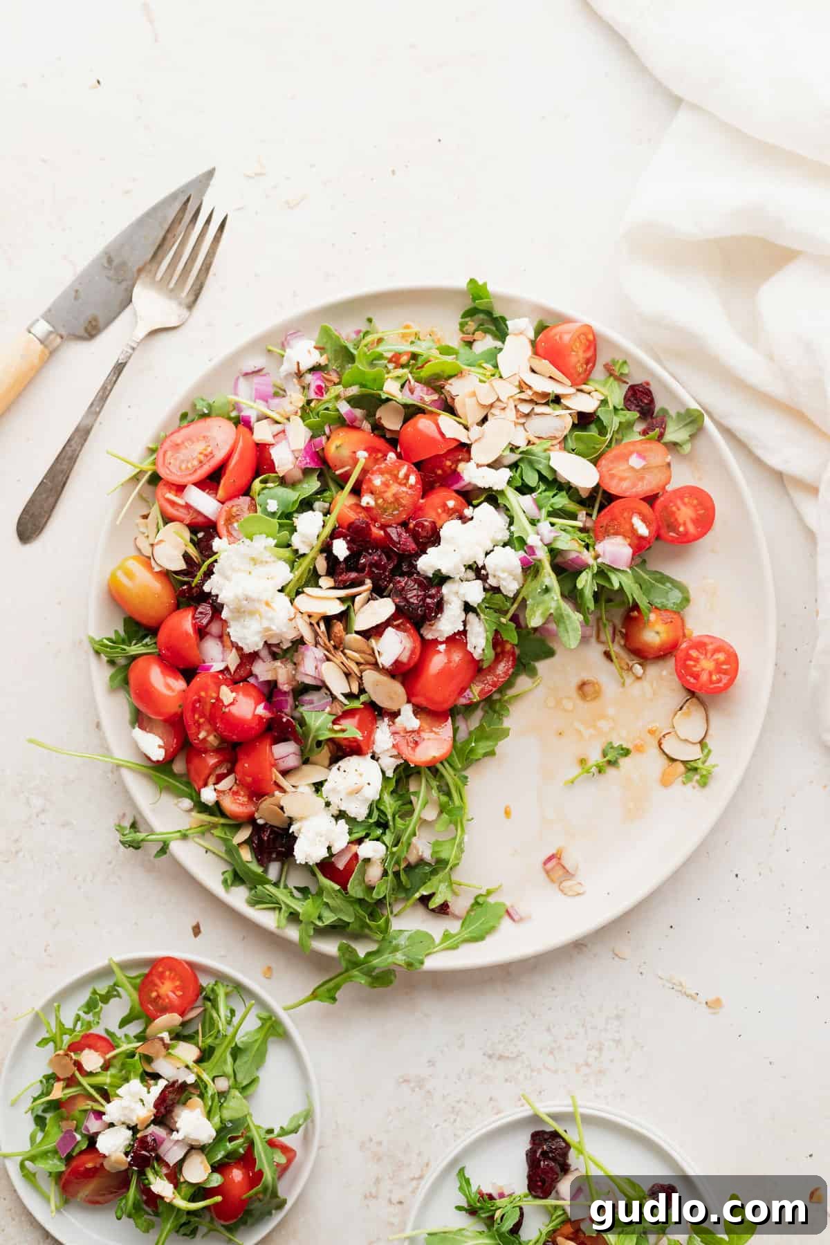 A freshly prepared arugula goat cheese salad on a plate, garnished and ready to be served, showcasing its vibrant appeal.