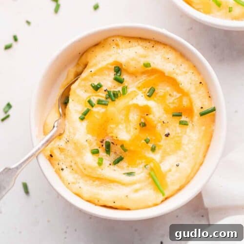 A vibrant bowl of cheese grits, perfectly creamy and golden, ready to be served and enjoyed.