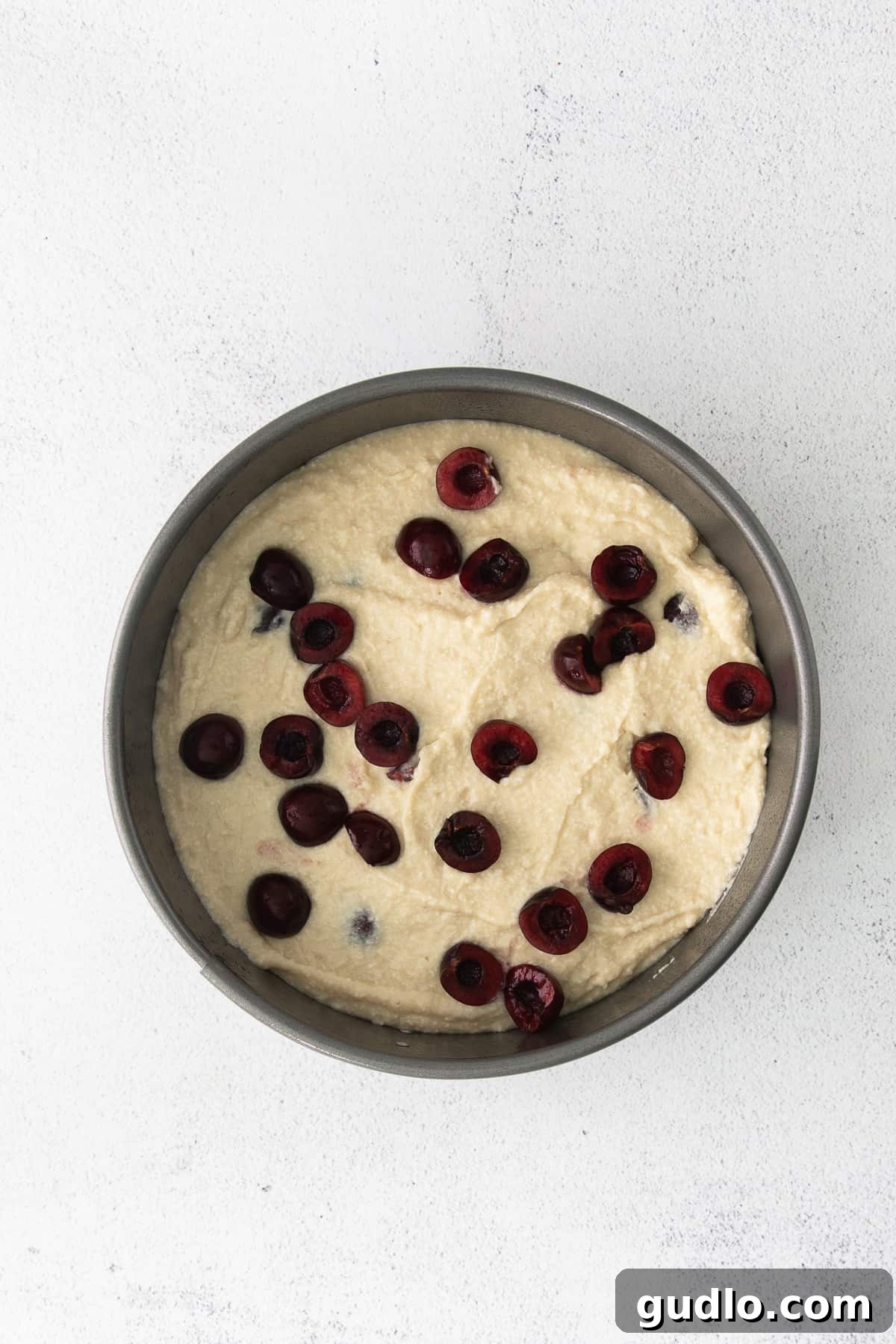 Velvety Cherry Ricotta Bliss 5 Cherry Ricotta Cake cooling in a springform pan, showcasing its golden crust and juicy cherries on top.