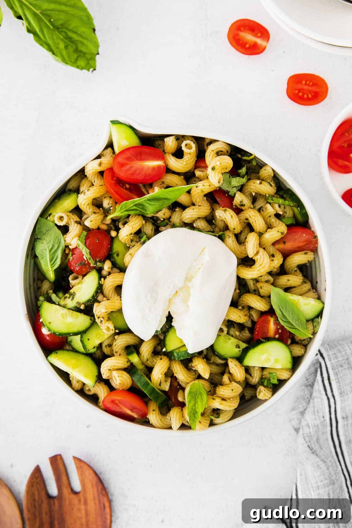 Pesto Pasta Salad with Burrata: A Fresh and Flavorful Dish A beautifully presented pesto pasta salad topped generously with creamy burrata in a rustic bowl, garnished with fresh basil.