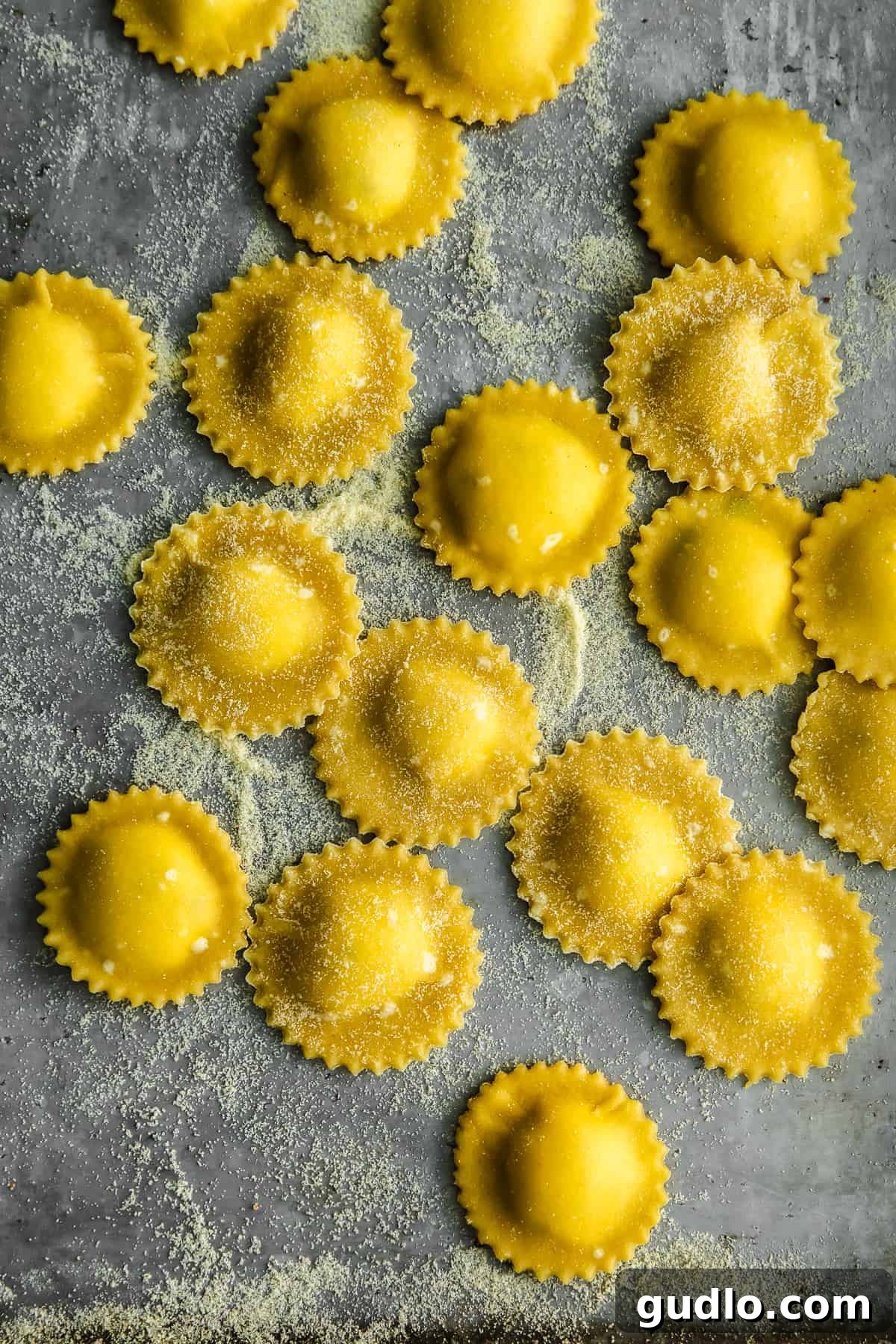 Goat Cheese Ravioli, Dusted and Ready Freshly made goat cheese ravioli lightly dusted with semolina flour, arranged on a baking sheet, ready for cooking or storage.
