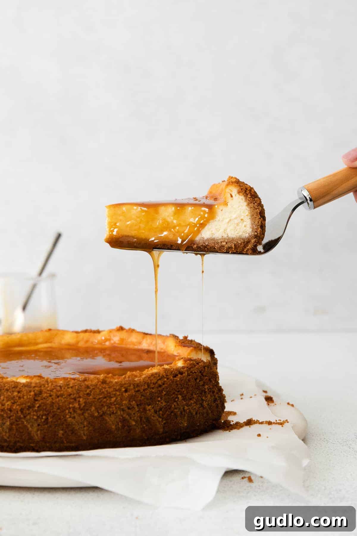 Salted Caramel Cheesecake Perfection 10 A slice of creamy salted caramel cheesecake being carefully lifted from the springform pan, showing off its crisp crust.