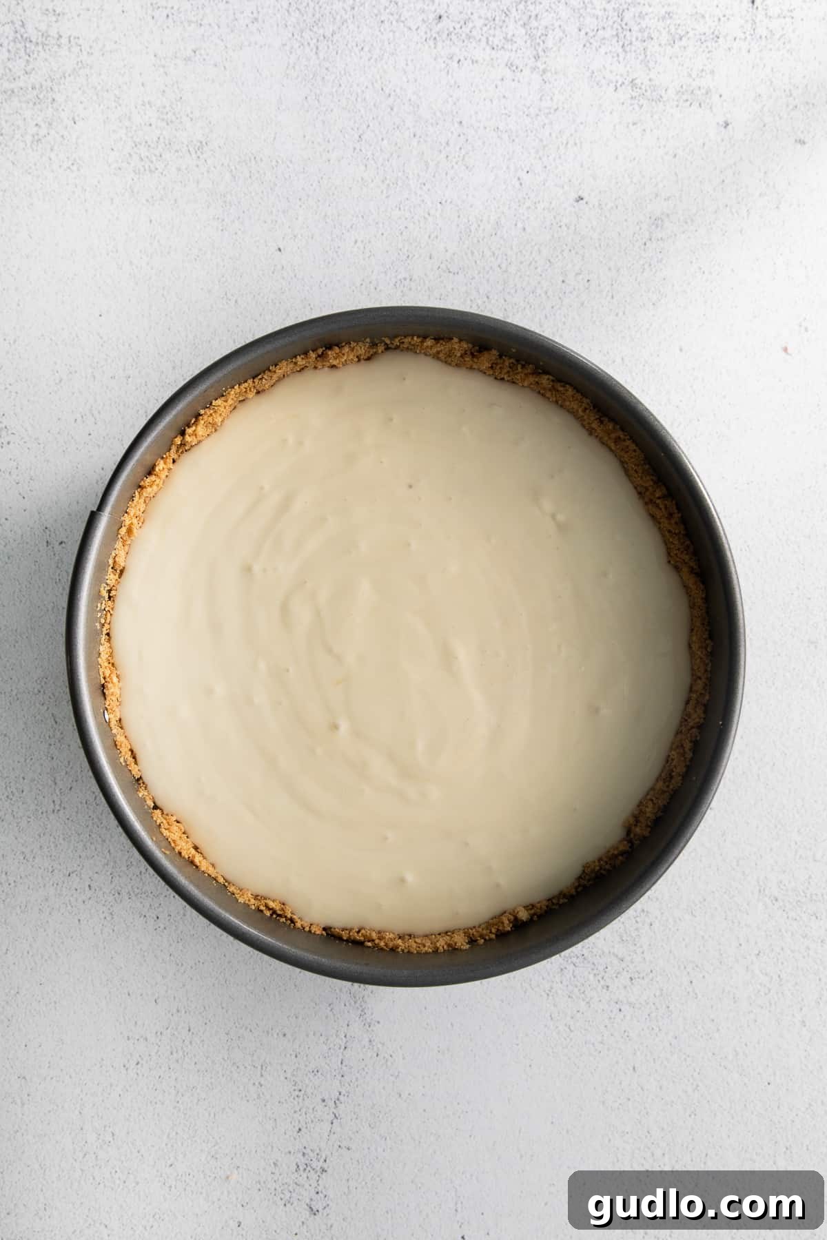 Salted Caramel Cheesecake Perfection 6 The unbaked salted caramel cheesecake filling poured into its graham cracker crust, ready for the oven.