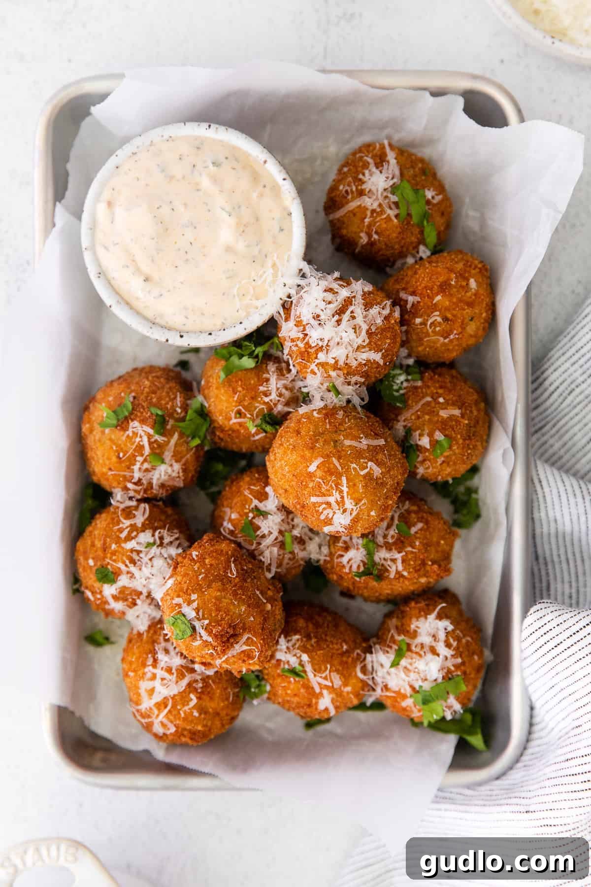 Got leftover risotto? Make Parmesan Arancini - a delicious fried rice ball appetizer! Crispy Parmesan Arancini served alongside a vibrant Calabrian Chili Ranch dipping sauce.