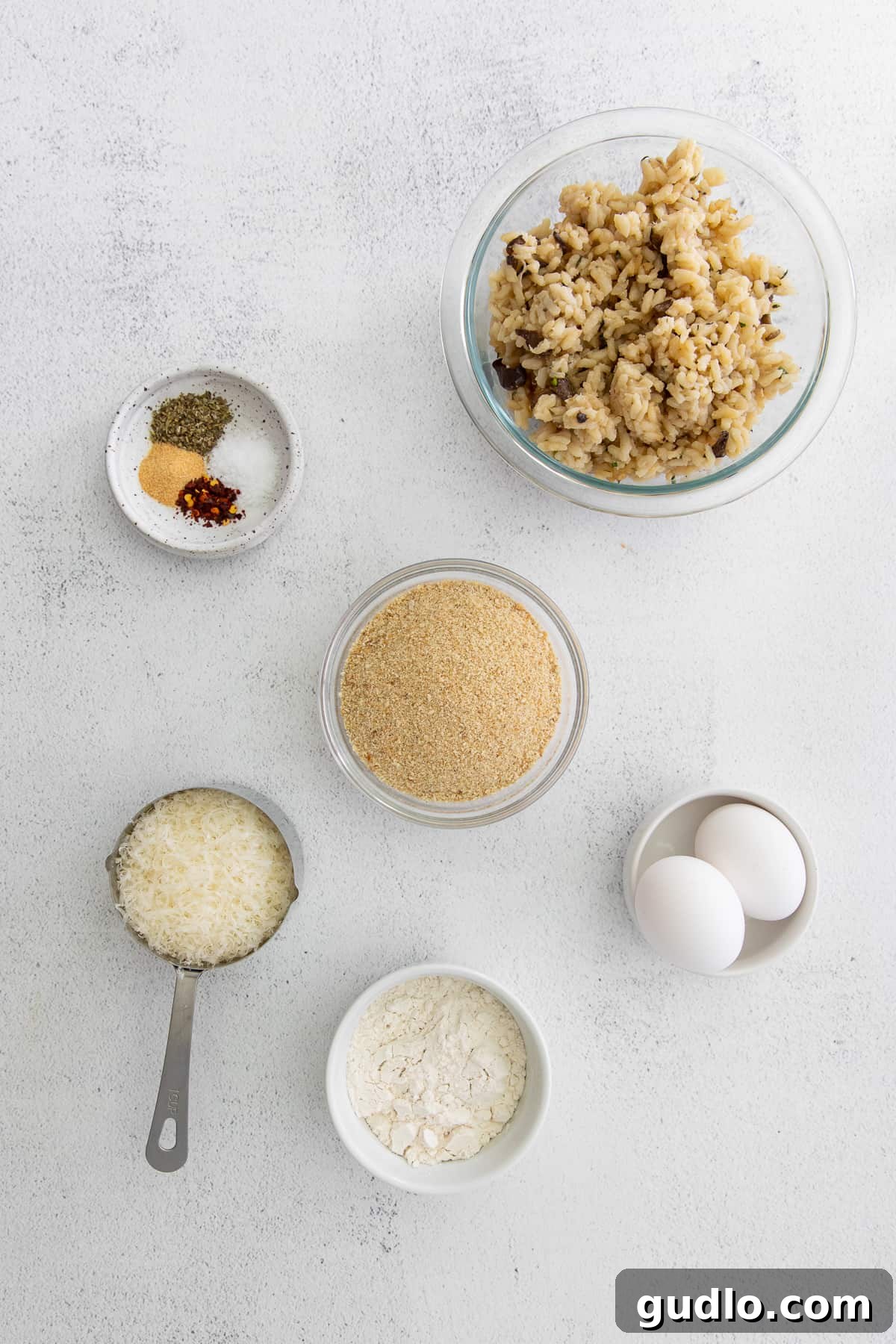 Got leftover risotto? Make Parmesan Arancini - a delicious fried rice ball appetizer! A collection of fresh ingredients for making arancini laid out on a kitchen countertop.