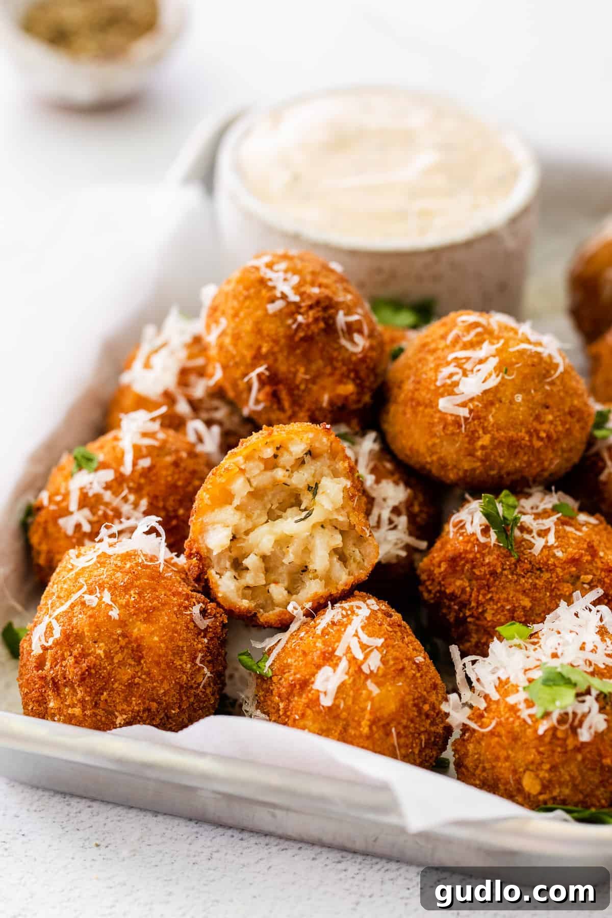 Make these delicious arancini balls with cooked risotto (arborio rice), parmesan cheese, breadcrumbs, and oil. A beautifully arranged platter of Parmesan Arancini, ready to be served and devoured.