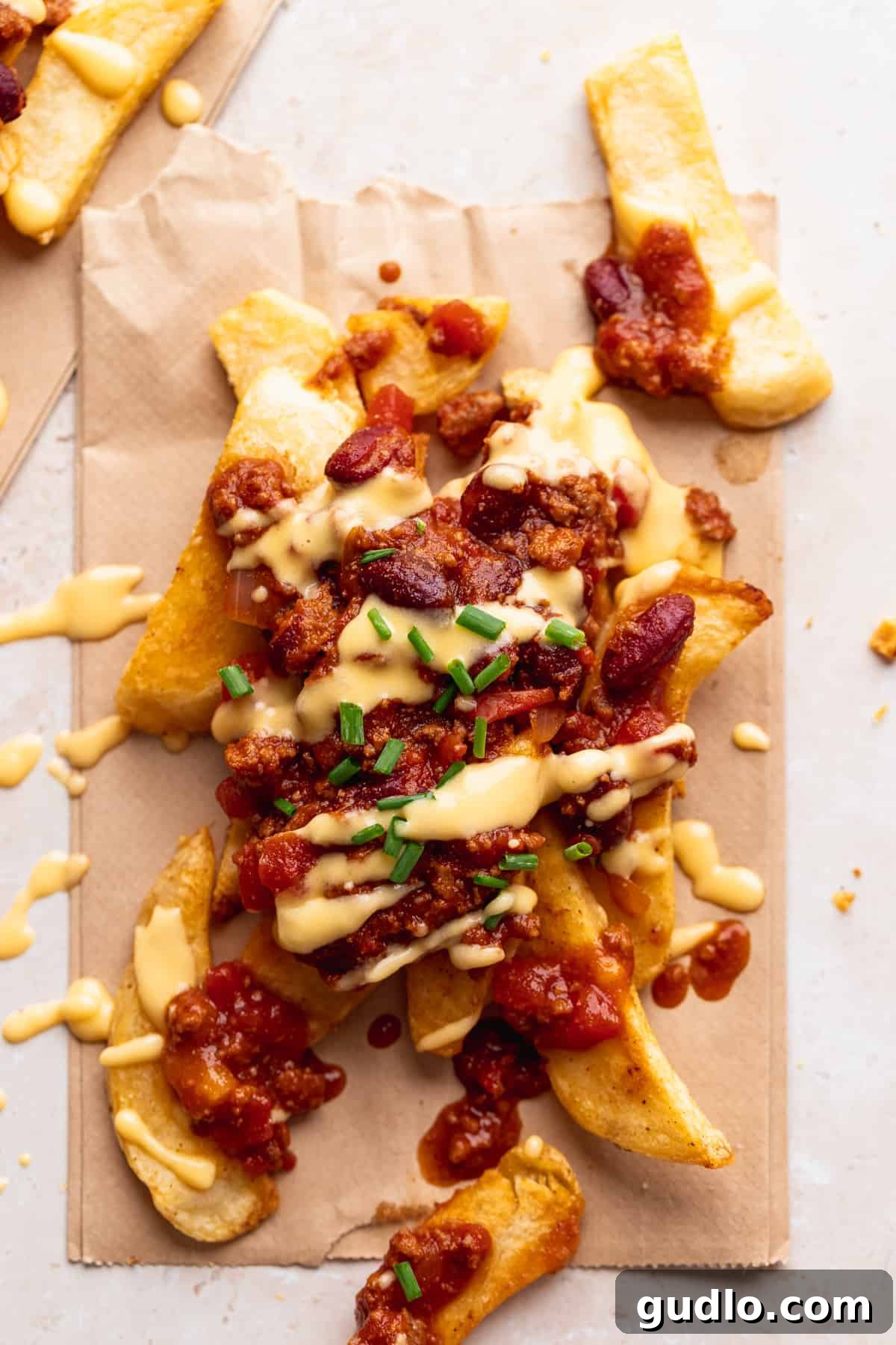 Homemade Chili Cheese Fries: The Perfect Game Day Snack Crispy chili cheese fries topped with fresh chopped chives, ready to serve