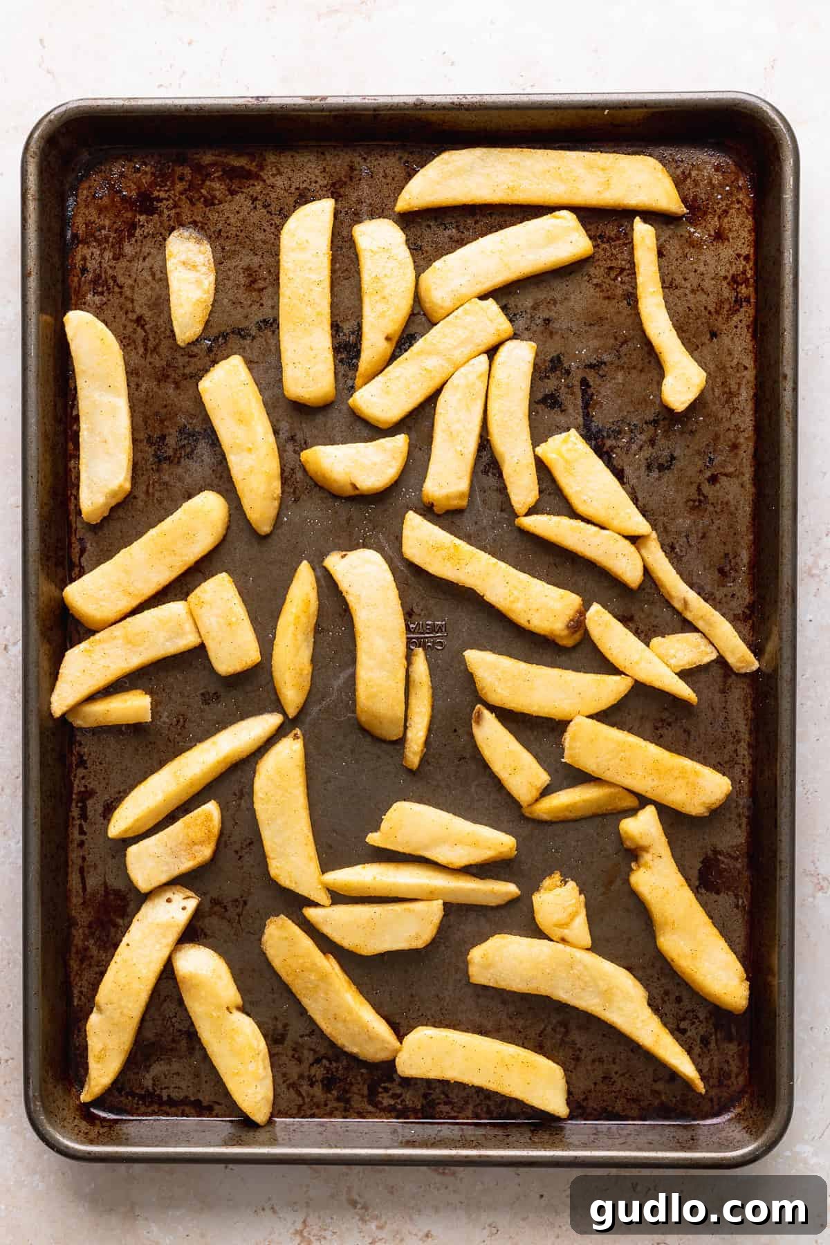 Prepping Potato Wedges for Chili Cheese Fries Thick cut potato wedges spread evenly on a baking sheet, ready for the oven