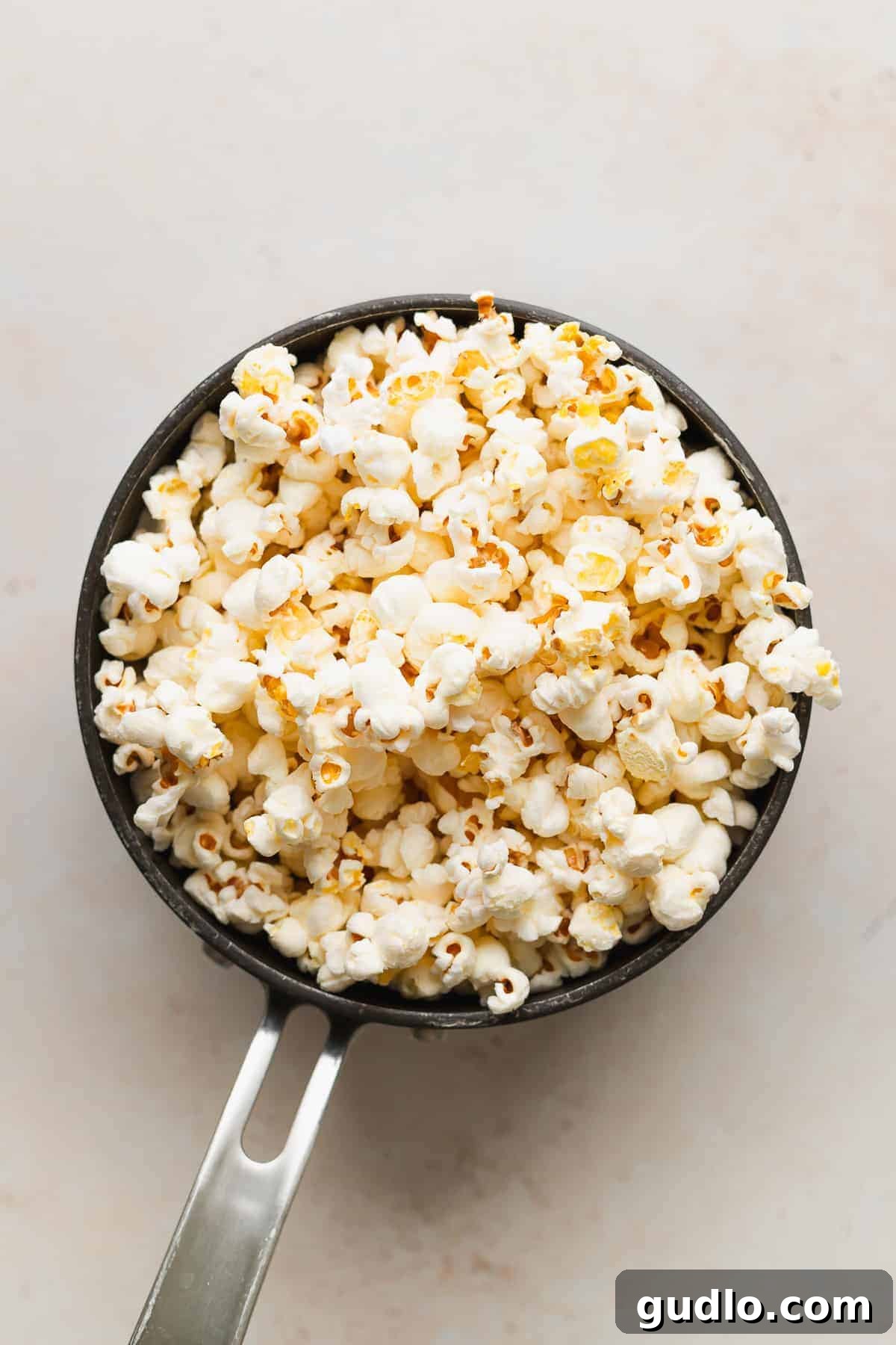 Artisanal Cheese Popcorn 3 A large bowl filled with plain, freshly popped popcorn, ready for seasoning.