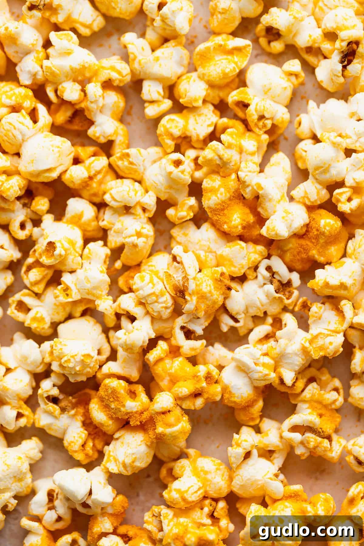 Artisanal Cheese Popcorn 6 A hand reaching into a bowl of freshly made homemade cheese popcorn, highlighting its irresistible texture.