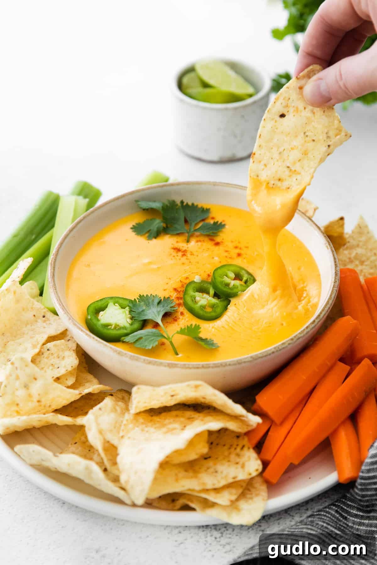 A golden tortilla chip generously coated in rich, velvety homemade nacho cheese sauce, perfect for game day or any snack time.