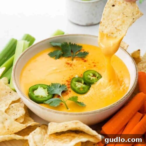 Close-up of a bowl of homemade nacho cheese dip, perfect for a party appetizer.