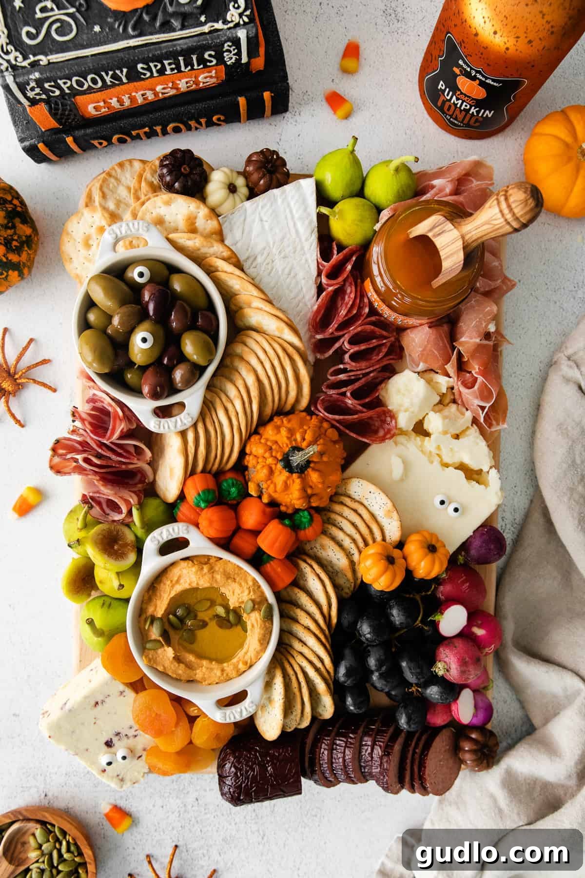 Ghoulish Grazing Board 2 A beautifully arranged Halloween cheese board featuring cheeses, meats, crackers, dark grapes, and spooky candy eyes.
