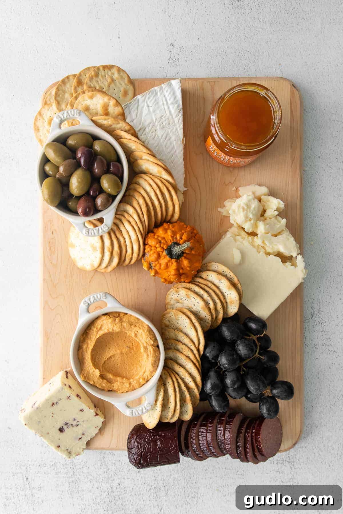 Ghoulish Grazing Board 4 Various crackers and breadsticks arranged on a Halloween cheese board next to cheeses and grapes.