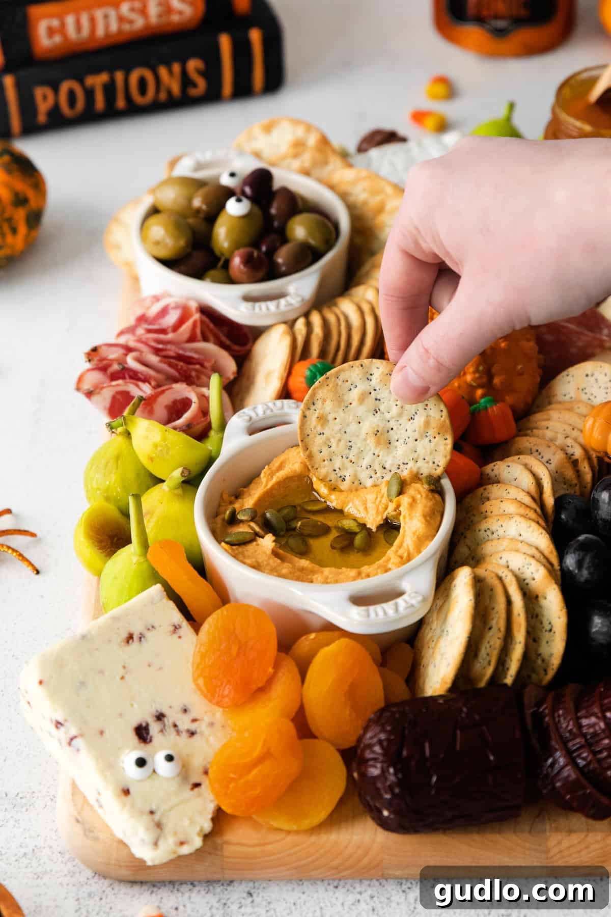 Ghoulish Grazing Board 7 An overhead shot of a Halloween cheese board with a wide assortment of cheeses, meats, and festive garnishes.