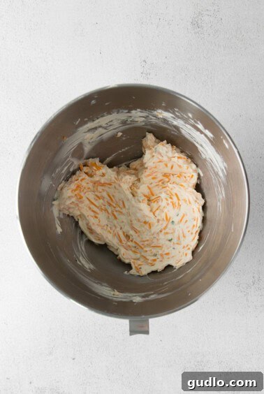 A metal mixing bowl filled with the creamy cheese ball mixture.