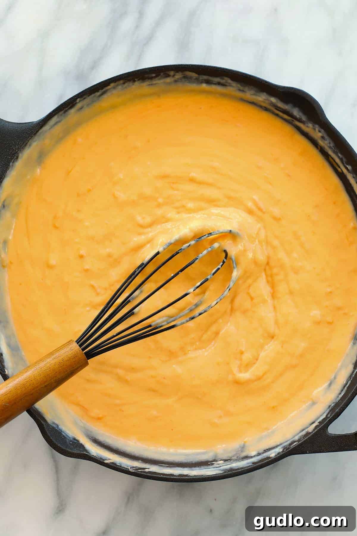 The perfect, velvety smooth cheese sauce base. Creamy mac and cheese sauce in a cast iron skillet.