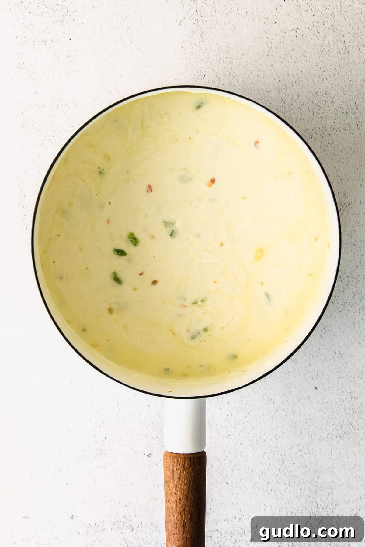 Luscious Homemade Queso Dip in a Pot A close-up of a pot filled with rich, golden homemade queso dip, showcasing its creamy texture, ready to be scooped.