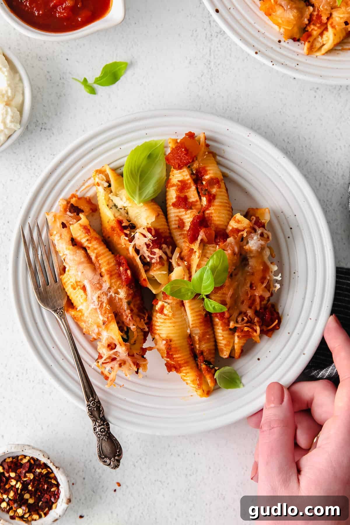 Delicious Ricotta Stuffed Shells - A Family Favorite Baked Pasta Meal Perfectly baked ricotta stuffed shells on a white plate, garnished with fresh herbs, ready to be served.