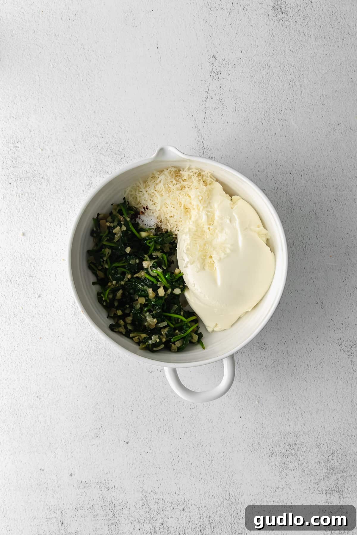 Creamy Ricotta Stuffing Mixture for Pasta Shells A bowl of creamy ricotta cheese filling for stuffed shells, mixed with herbs and other ingredients, ready for use.