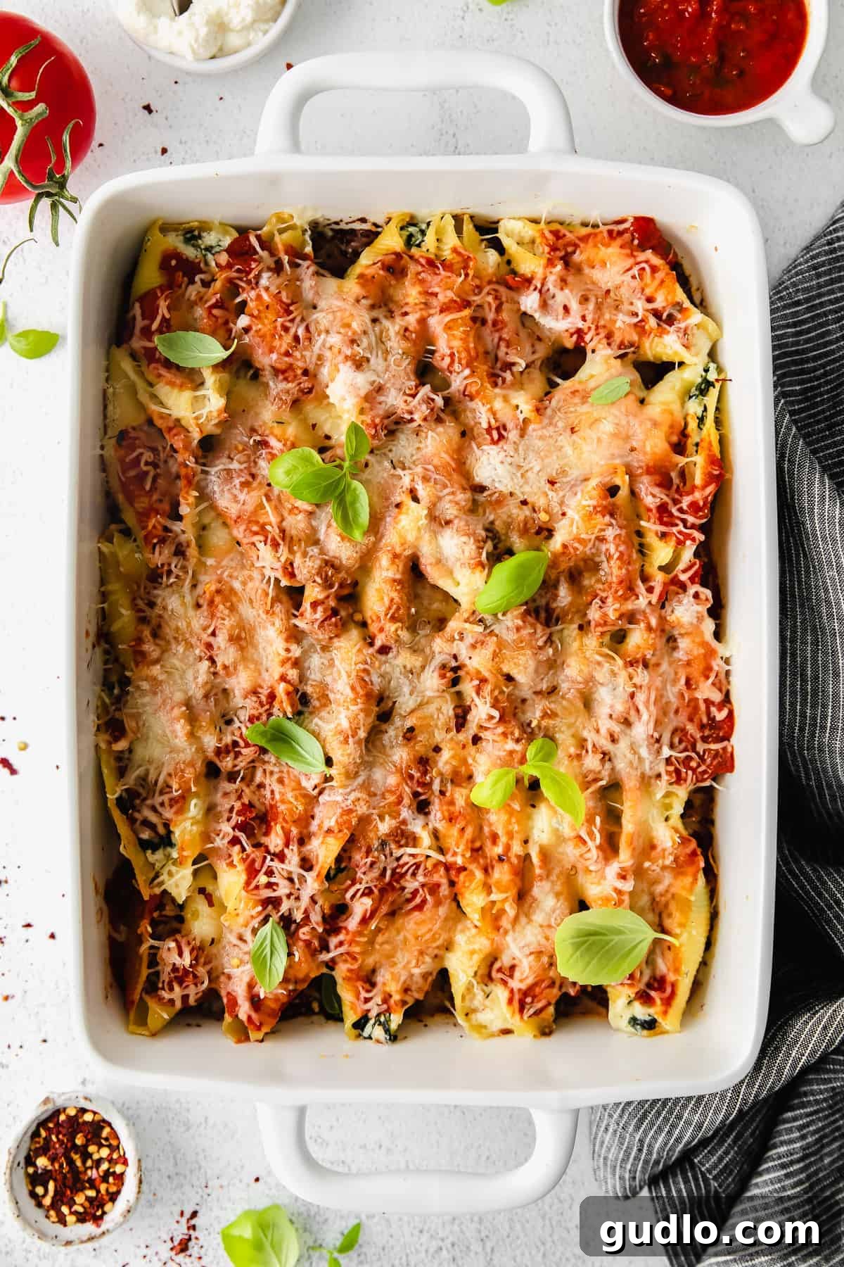 Hot and Bubbly Ricotta Stuffed Shells After Baking Freshly baked ricotta stuffed shells in a casserole dish, topped with melted cheese and basil, straight from the oven.