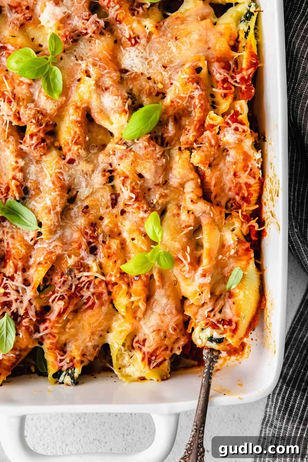 Close-up of a Ricotta Stuffed Shell on a Spoon A single ricotta stuffed shell resting on a fork, showcasing its creamy filling and melted cheese.