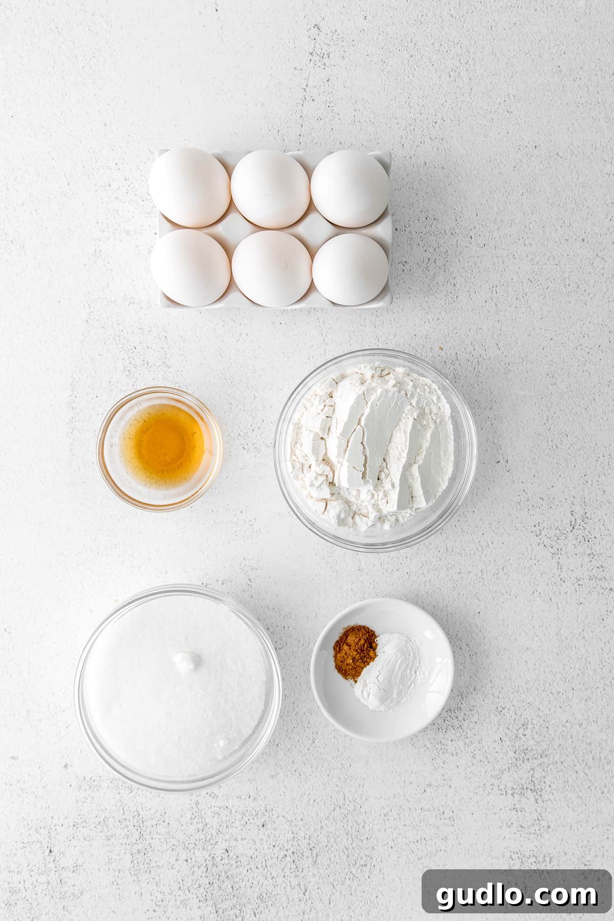 Various ingredients for Tiramisu Layer Cake meticulously arranged in small, elegant bowls, ready for preparation.