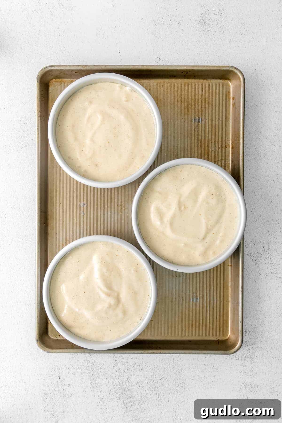 Three golden sponge cake layers perfectly baked and cooling, ready to be assembled into a Tiramisu Layer Cake.