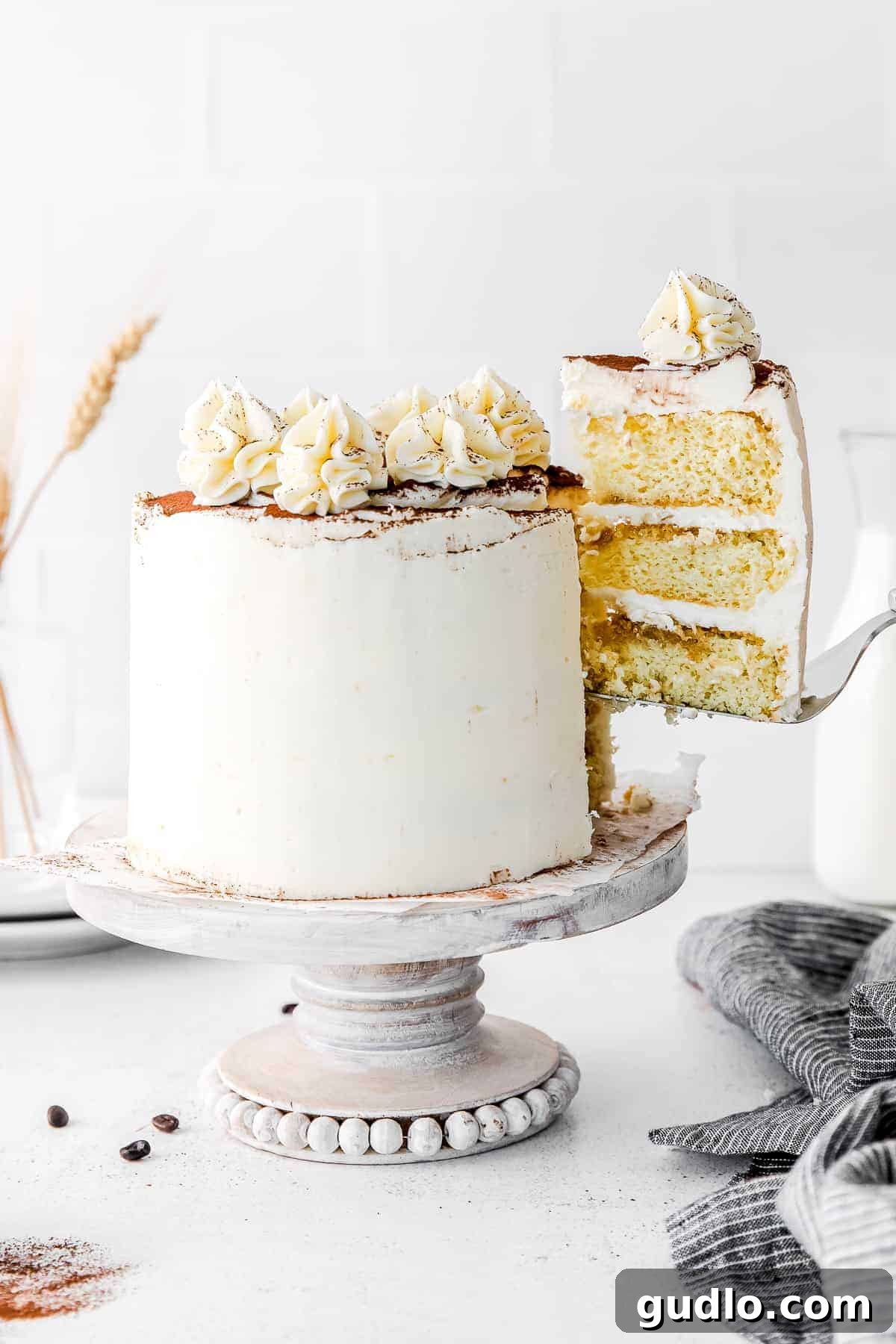 A delicate slice of Tiramisu Layer Cake being carefully removed, showcasing its beautiful layers.